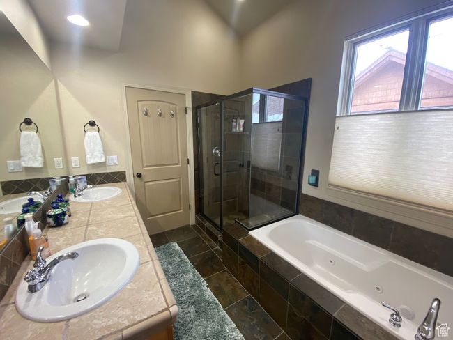 Full bathroom with a healthy amount of sunlight, a stall shower, a tub with jets, and a sink | Image 11