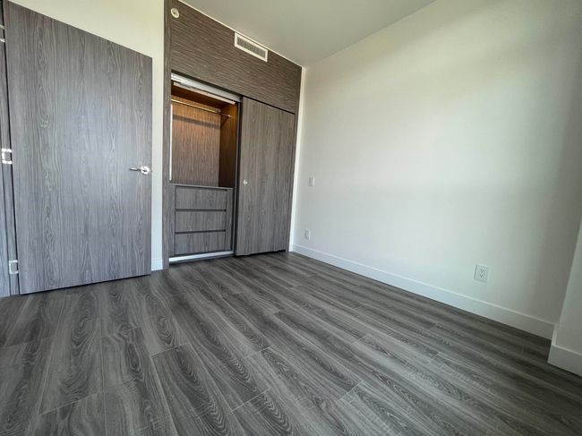 Unfurnished bedroom with dark wood-style floors, a closet, visible vents, and baseboards | Image 17