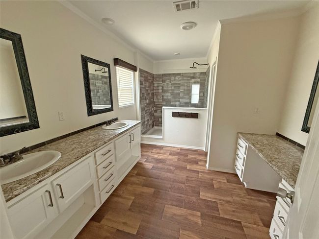 Full bathroom featuring walk in shower, crown molding, double vanity, and wood finished floors | Image 10