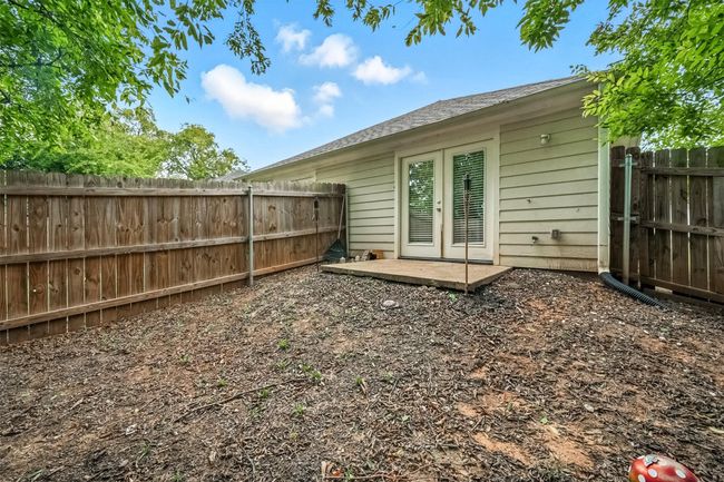 Back of property with french doors, a fenced backyard, and a shingled roof | Image 16
