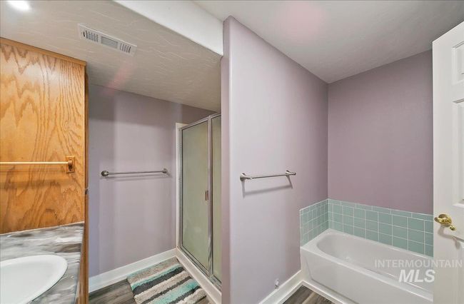Bathroom with a garden tub, a stall shower, and vanity | Image 30