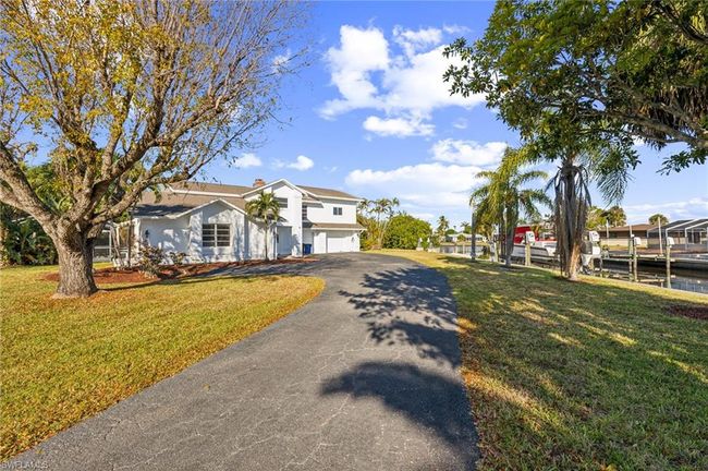 Traditional home with an attached garage, a front yard, and aphalt driveway | Image 12