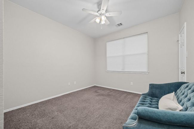 Living area with carpet flooring, visible vents, ceiling fan, and baseboards | Image 29