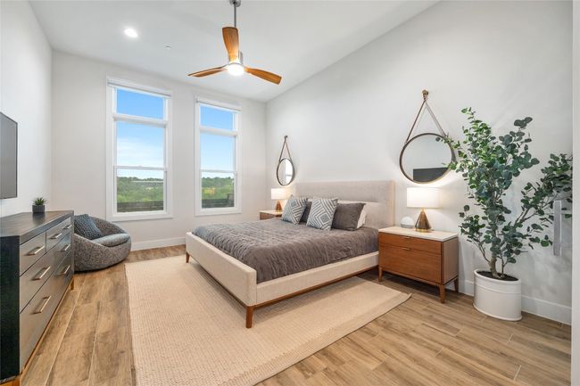 Rare, generously sized ground floor primary bedroom with large windows overlooking manicured lawn leading to shoal creek. Motorized blinds offer versatile blackout and translucent options. | Image 11