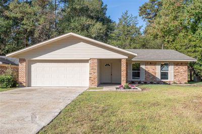 Ranch-style home with a garage and a front lawn | Image 1