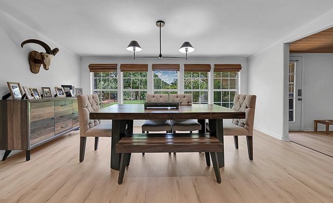 Dining area with light wood-style flooring, crown molding, and recessed lighting | Image 9