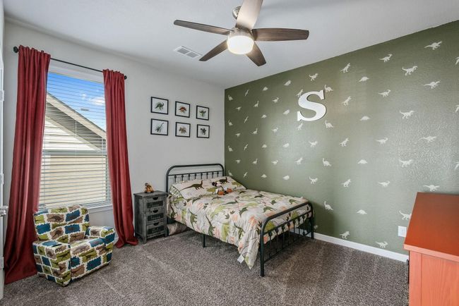 4th bedroom featuring multiple windows, a ceiling fan, and baseboards | Image 23