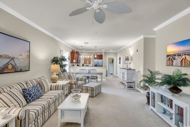 Living area with light carpet, ceiling fan, and ornamental molding | Image 5