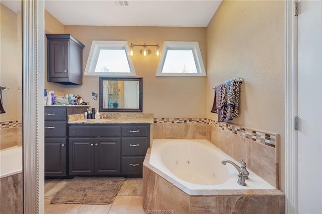 Bathroom featuring vanity, healthy amount of natural light, and a whirlpool tub | Image 18