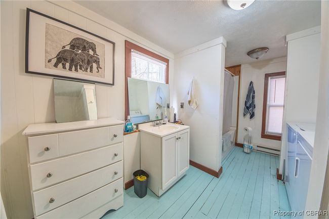 Full bath with vanity, wood finished floors, baseboard heating, and a healthy amount of sunlight | Image 33