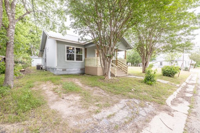 View of front of property with a front yard, central AC, covered porch, metal roof, and crawl space | Image 26