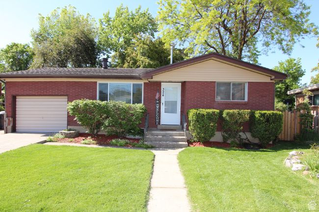 View of front of property featuring an attached garage, brick siding, and concrete driveway | Image 4