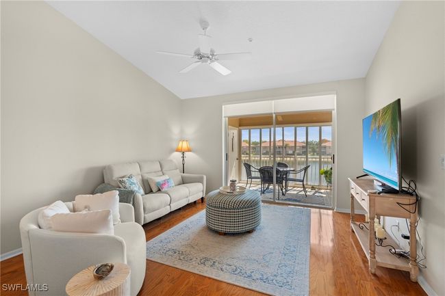 Living area featuring baseboards, wood finished floors, ceiling fan, and lofted ceiling | Image 4