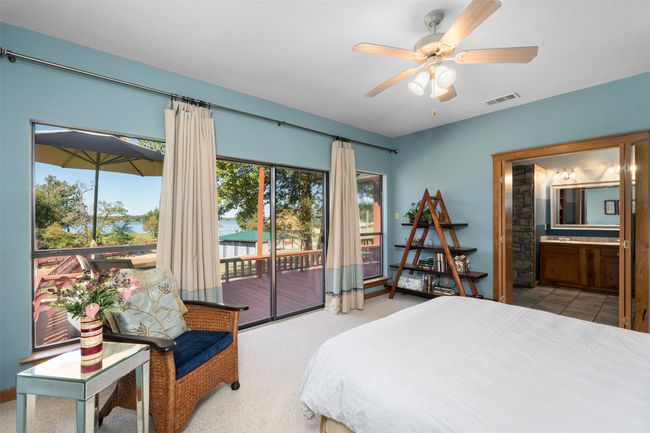Bedroom featuring ceiling fan, connected bathroom, and access to outside | Image 18