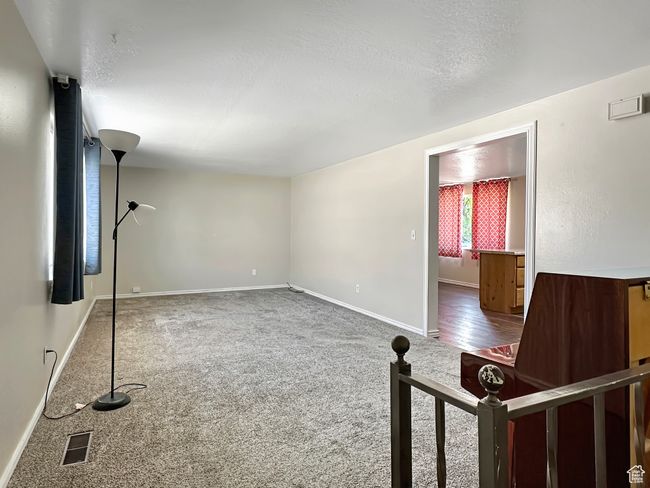 Unfurnished living room with carpet, baseboards, and a textured ceiling | Image 12