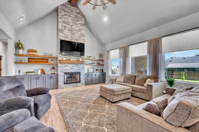 Living area with high vaulted ceiling, hardwood / wood-style flooring, a fireplace, a ceiling fan, and beamed ceiling | Image 15