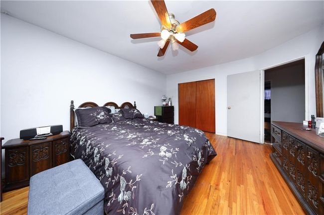 Bedroom with a closet, wood finished floors, and a ceiling fan | Image 17