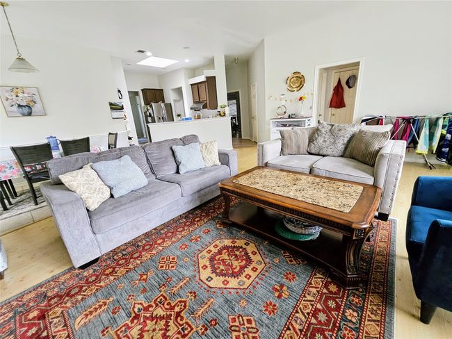 Living area with light wood-type flooring and a skylight | Image 4
