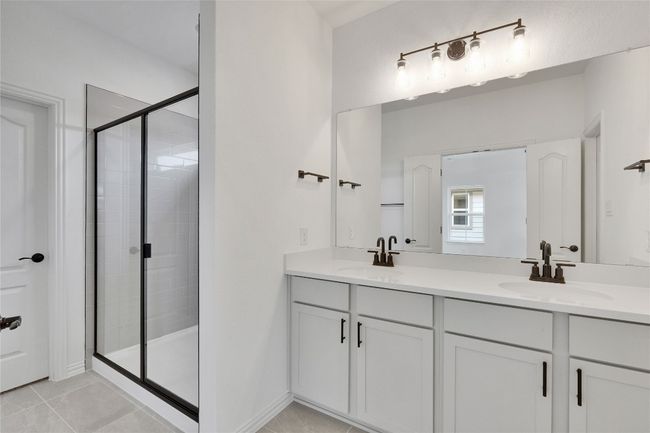 Full bath with double vanity, a shower stall, and tile patterned floors | Image 6