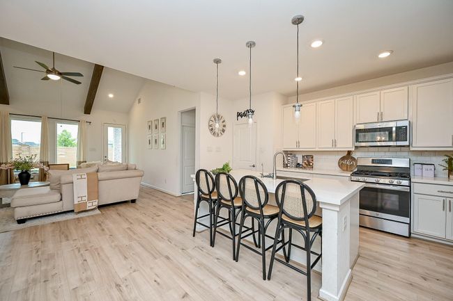 The kitchen includes a spacious bar area, perfect for entertaining guests with extra seating while staying connected to the action. | Image 11