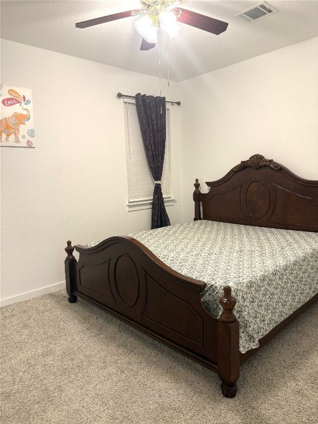 Bedroom with light carpet, a ceiling fan, and baseboards | Image 18