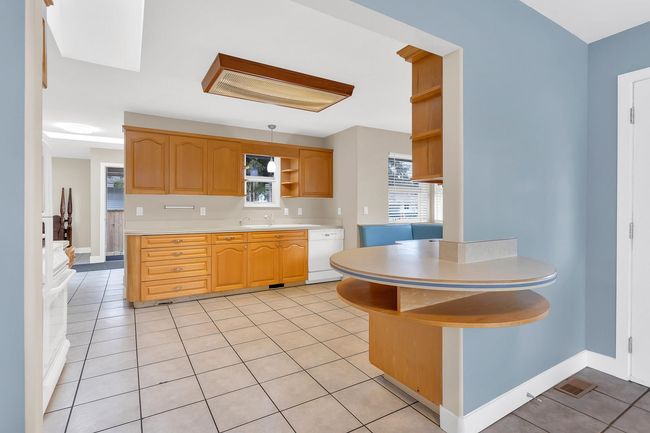 Kitchen featuring light countertops, open shelves, dishwasher, light tile patterned floors, and visible vents | Image 10