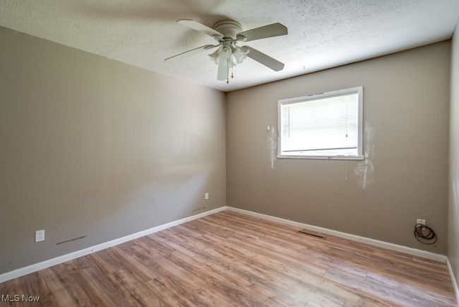 Spare room with wood finished floors, ceiling fan, baseboards, and a textured ceiling | Image 31