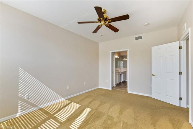 Unfurnished bedroom featuring light carpet, baseboards, visible vents, and ensuite bathroom | Image 23