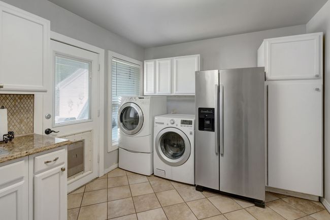 Laundry area featuring washer and clothes dryer and light tile patterned floors | Image 11