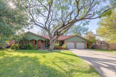 Single story home featuring a garage and a front yard | Image 1