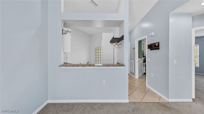 Spare room featuring light colored carpet, baseboards, visible vents, and light tile patterned floors | Image 9
