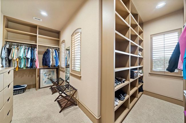 With custom built-in cabinetry, the primary bedroom closet is a perfect blend of luxury and practicality, offering abundant storage and a sleek, tailored look | Image 25