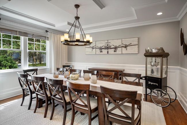 Dining area featuring a wainscoted wall, wood finished floors, ornamental molding, and a chandelier | Image 6