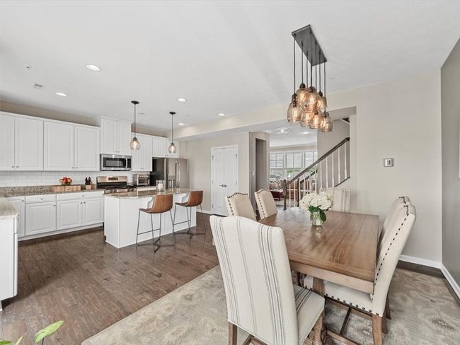 The adjacent dining space is bright and inviting, perfect for both everyday meals and formal gatherings, all set against rich hardwood floors and a neutral color palette. | Image 8