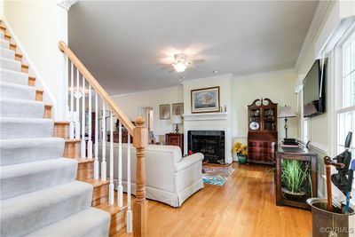 Great room featuring ceiling fan, hardwood floors and gas fireplace | Image 2