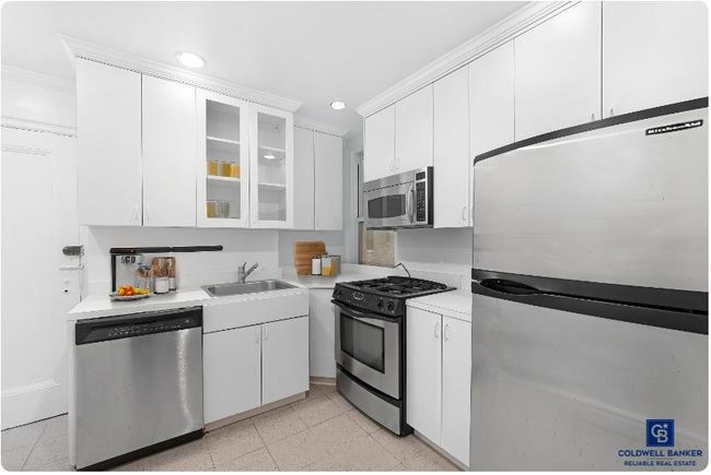Kitchen with recessed lighting, stainless steel appliances, light countertops, a sink, and white cabinetry | Image 8
