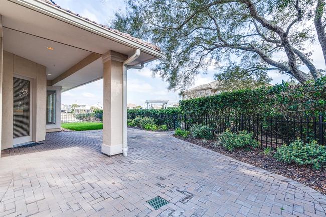 Extended paver patio with covered area and water views. | Image 46