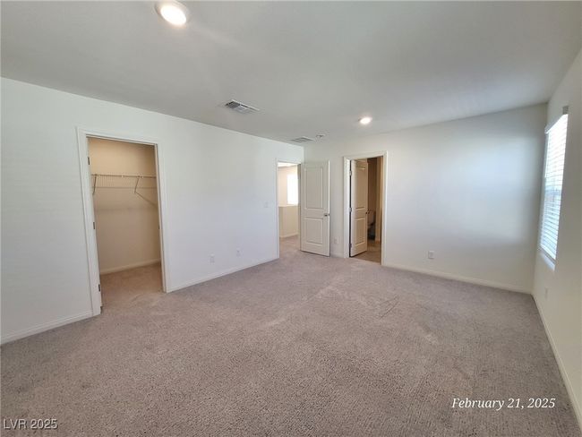 Unfurnished bedroom featuring light carpet, visible vents, a spacious closet, and baseboards | Image 15