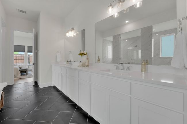 Ensuite bathroom featuring double vanity, visible vents, a marble finish shower, and a sink | Image 29
