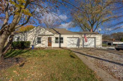 Ranch-style home with a garage and a front lawn | Image 1