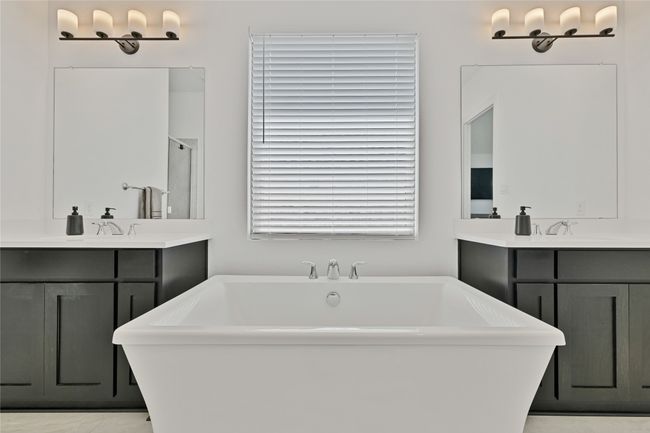 Full bathroom featuring a freestanding bath, two vanities, and a shower with shower door | Image 27