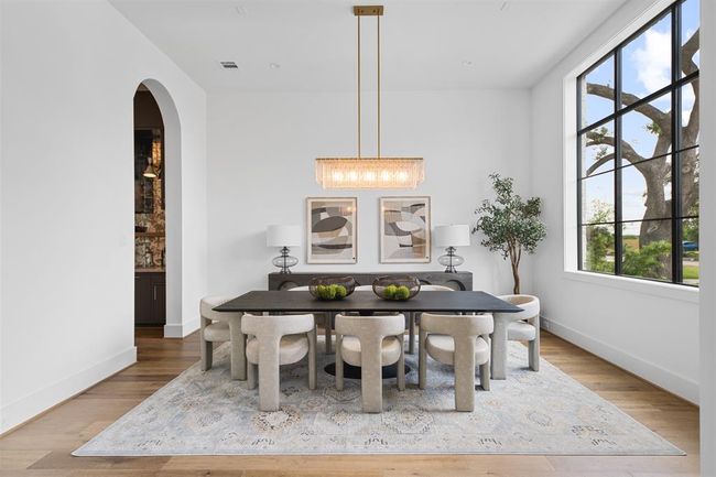 This elegant formal dining room offers a versatile space with abundant natural light, high ceilings, and a statement chandelier, making it perfect for hosting or transforming into a stylish home office or lounge. | Image 5