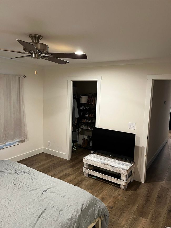 Bedroom with wood finished floors, a walk in closet, and a ceiling fan | Image 17