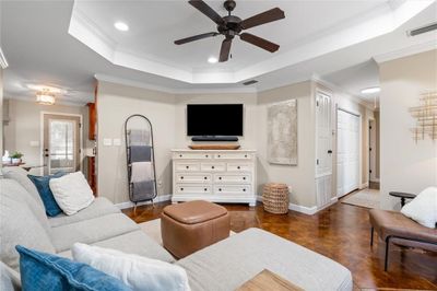 Tiled living room with ornamental molding, ceiling fan, and a raised ceiling | Image 3