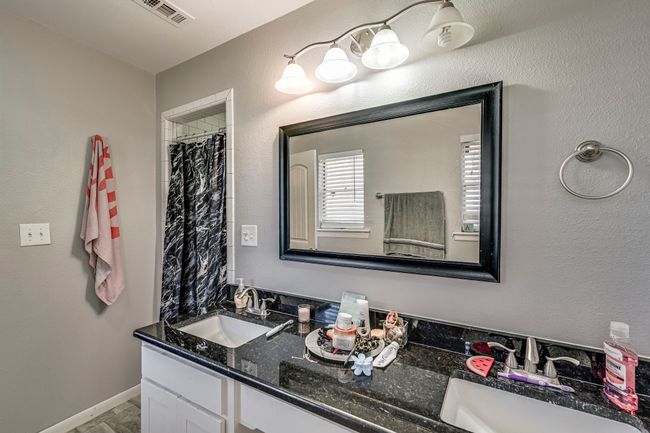 Bathroom featuring double vanity, baseboards, visible vents, and a sink | Image 7