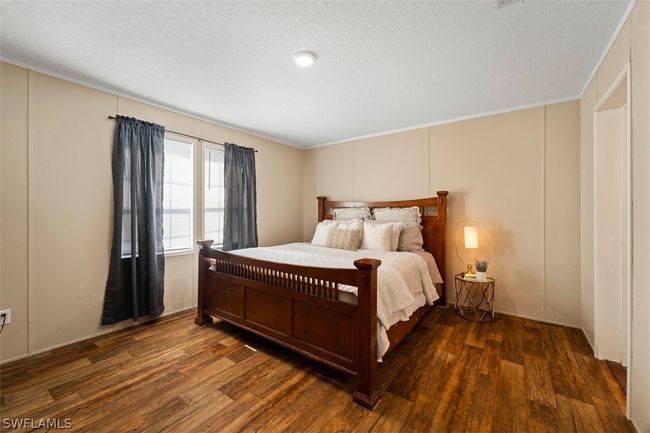 Bedroom with dark hardwood / wood-style floors, ornamental molding, and a textured ceiling | Image 17