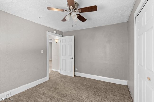 Unfurnished bedroom with carpet, a closet, a textured ceiling, and baseboards | Image 14