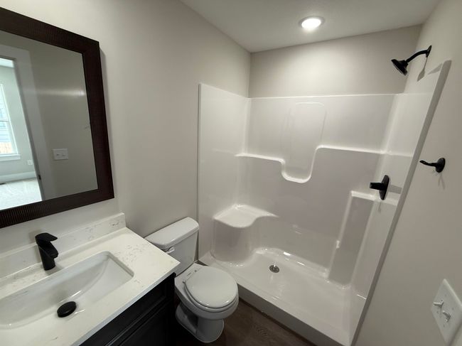 Full bath featuring vanity, toilet, a shower, and wood finished floors | Image 9