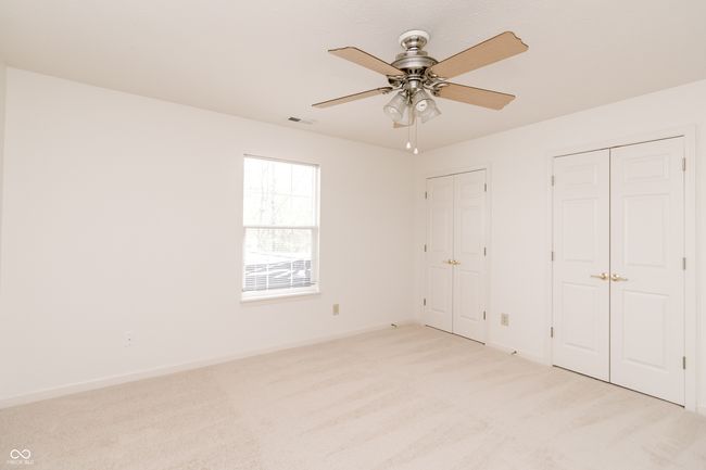 unfurnished bedroom featuring multiple closets, ceiling fan, light carpet, baseboards, and visible vents | Image 24