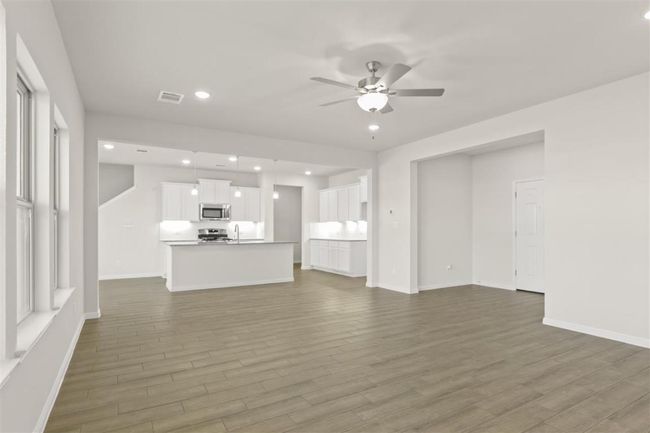Unfurnished living room featuring baseboards, a ceiling fan, and wood finished floors | Image 7